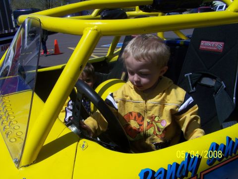 1972 Ford Ranchero - A young child sits in the driver's seat of a bright yellow go-kart.