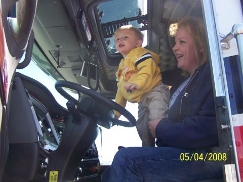 1972 Ford Ranchero - A woman and a young child are inside the cab of a truck, with the child appearing to play with the steering wheel.