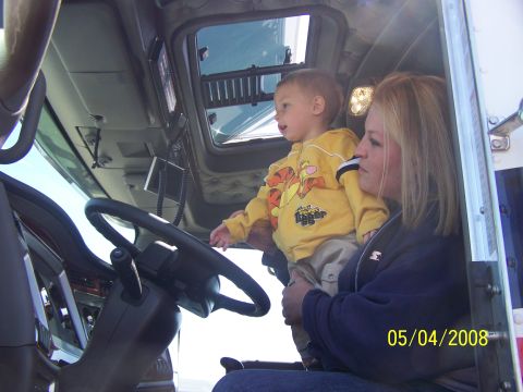 1972 Ford Ranchero - A woman holds a young child in the cab of a large truck.