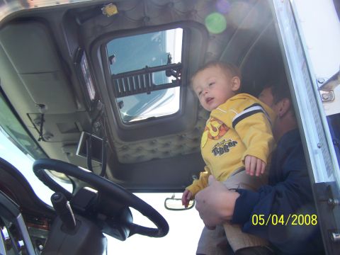 1972 Ford Ranchero - A child looks out from the interior of a semi-truck cab, with an adult holding them. The photo is dated 05/04/2008.