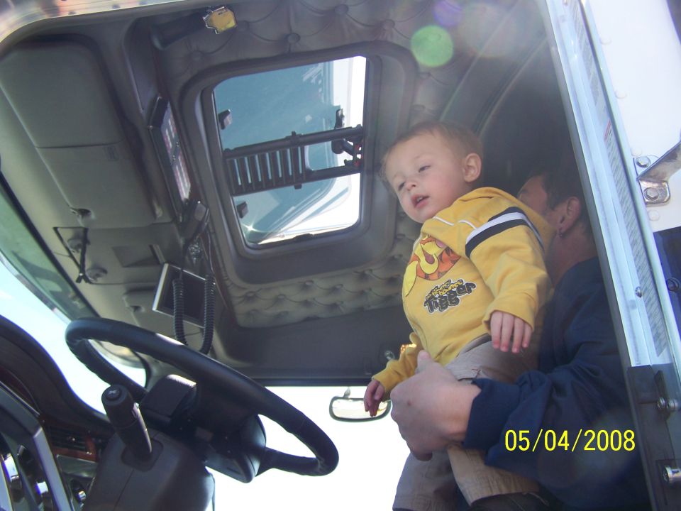 Interior of semi-truck cab with child and adult; date stamp 05/04/2008