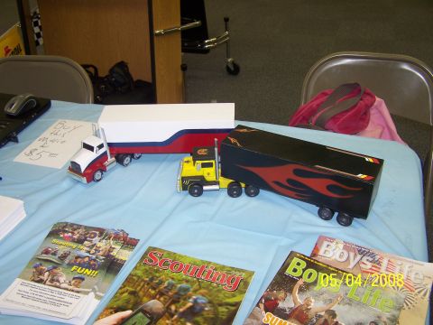 1972 Ford Ranchero - Two model semi-trucks are displayed on a table with magazines and a sign.
