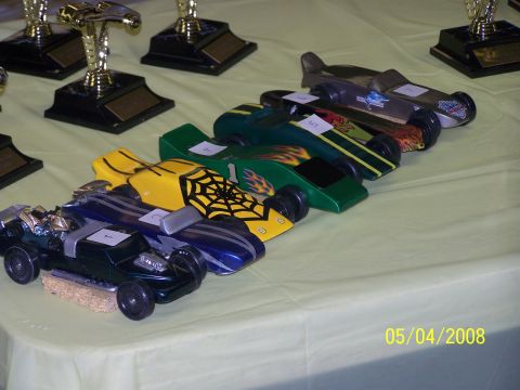 1972 Ford Ranchero - Model cars lined up on a table with trophies, likely for a race event.