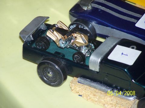1972 Ford Ranchero - A toy car with a gold engine is visible in the bed of a dark green toy pickup truck.