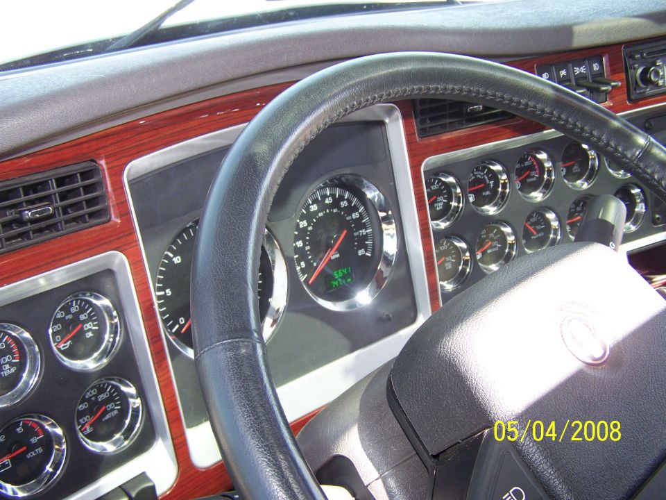Dashboard of a truck with wood trim, multiple gauges, and a steering wheel. Date stamp reads 05/04/2008