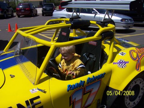 1972 Ford Ranchero - A child sits in the driver's seat of a yellow racing go-kart with a large rear spoiler.
