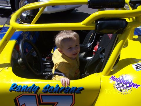 1972 Ford Ranchero - A young child sits in the driver's seat of a yellow racing kart, with racing decals visible on the body.