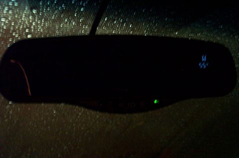 2001 Ford Crown Victoria - A dark interior shot captures a rear-view mirror with a green light and a digital display.