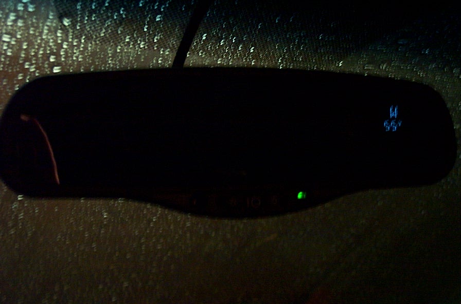 Rear-view mirror with a green indicator light and digital display showing "W" and "55"