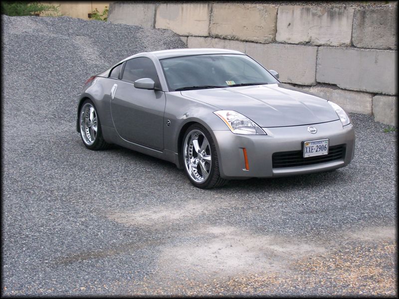 Silver 2003 Nissan 350Z coupe with chrome wheels parked on gravel