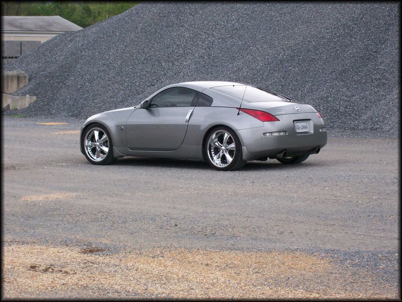 Silver 2003 Nissan 350Z parked on gravel lot with pile of rocks behind it