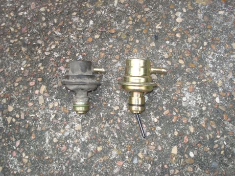 1989 Ford Bronco II - Comparing a used black fuel pressure regulator with a new gold one.