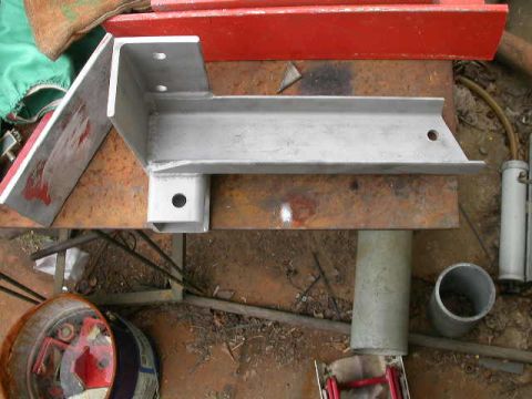 1990 Ford Bronco - Metal bracket assembly on a workbench, possibly for automotive use.