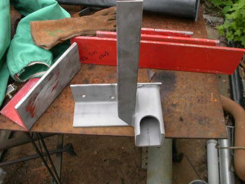 1990 Ford Bronco - Metal fabrication parts and protective gear are laid out on a weathered workbench.