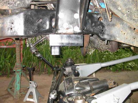 1990 Ford Bronco - Close-up of vehicle frame and suspension components supported by jack stands.