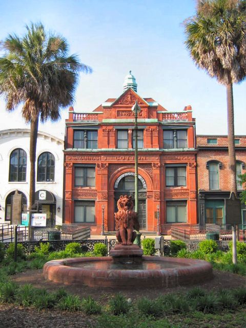 1985 Ford LTD Crown Victoria - The historic Savannah Cotton Exchange building stands prominently with a fountain and lion statue in the foreground.