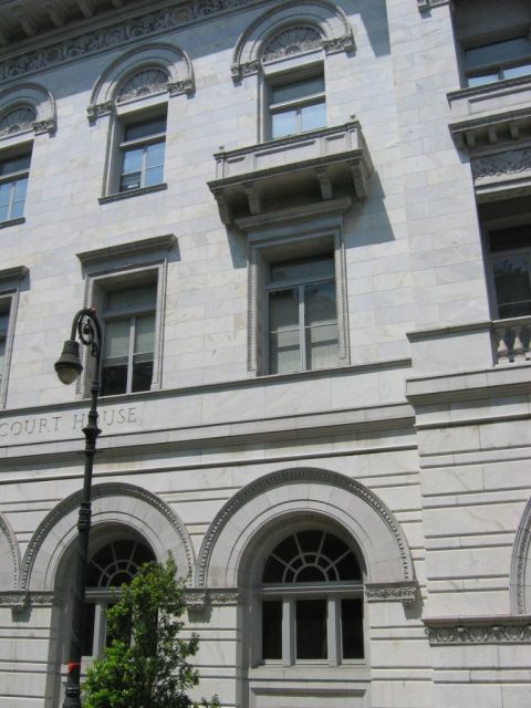 1985 Ford LTD Crown Victoria - The facade of a courthouse building features ornate architectural details and multiple windows.