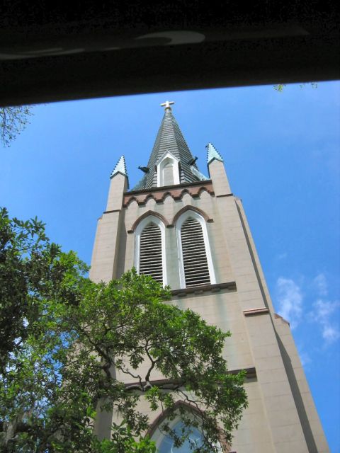 1985 Ford LTD Crown Victoria - A church steeple rises against a clear blue sky, with green trees in the foreground.