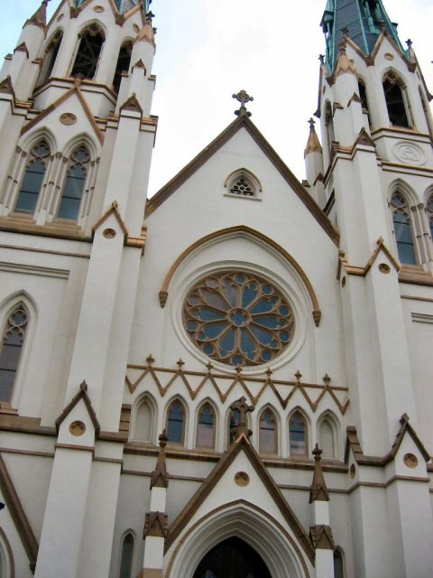 1985 Ford LTD Crown Victoria - The facade of a cathedral features a large rose window and ornate architectural details.
