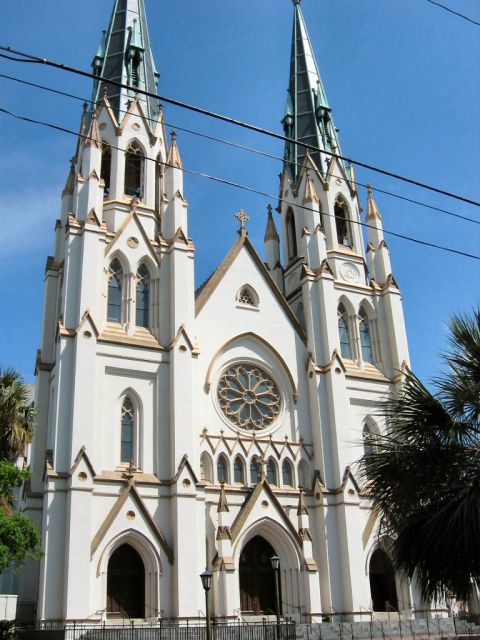 1985 Ford LTD Crown Victoria - A white cathedral with gothic architecture and two tall spires stands against a clear blue sky.