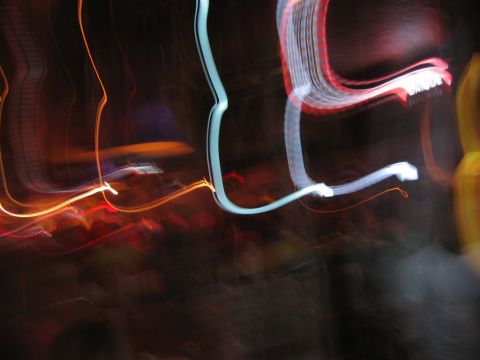 1985 Ford LTD Crown Victoria - Blurry streaks of light suggest movement and urban nightlife.