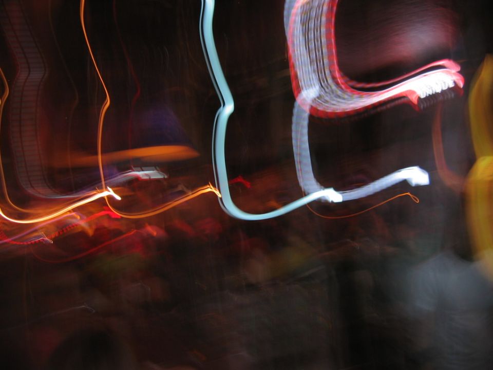 Abstract light trails in red, orange, and blue against a dark background