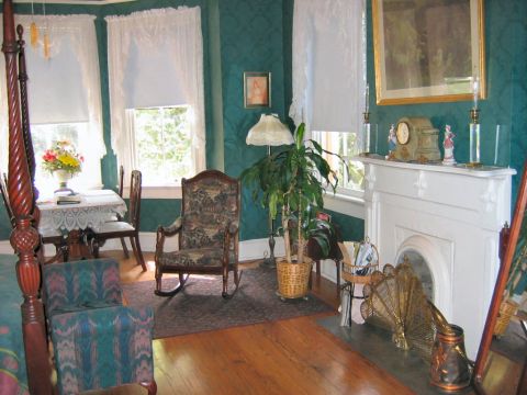 1985 Ford LTD Crown Victoria - A view of a room antique furniture, including a bed, a rocking chair, and a decorative fireplace with a mantel clock.