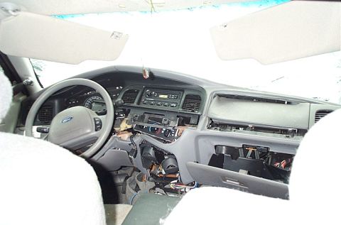 2001 Ford Crown Victoria - Interior shot of a sedan with steering wheel, sun visors and dash partially torn down exposing wiring and HVAC components.