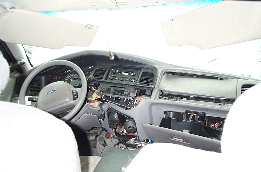 Car interior with disassembled dashboard, glove box open and wiring exposed