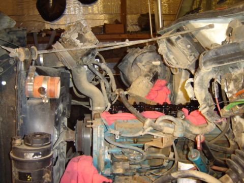1992 Ford Bronco - The engine bay of a truck is shown with some components removed, revealing the engine block and valves.