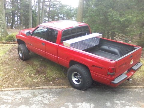 1997 Dodge 1500 - Red 1997 Dodge 1500 pickup truck seen from a 3/4 front angle, parked outdoors.