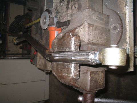 1979 Ford Bronco - A metal rod is secured in a vise, ready for modification with an angle grinder.