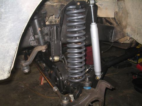 1979 Ford Bronco - The image shows the front suspension system of a vehicle, including the steering linkage, coil spring, and shock absorber.