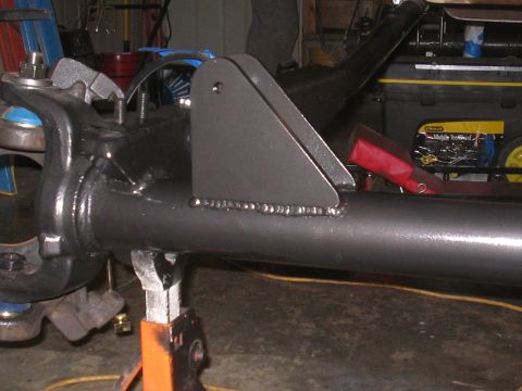 1979 Ford Bronco - Custom bracket welded onto a vehicle axle assembly, shown on a jack stand in a workshop.