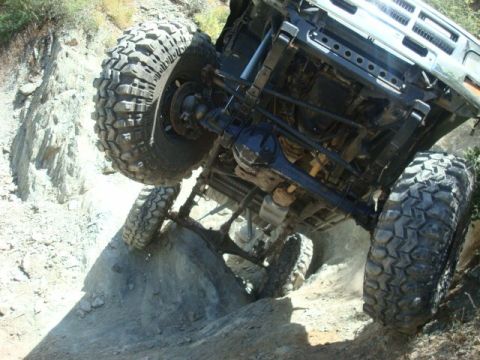 1986 Toyota Hilux - This truck is navigating a challenging off-road trail, with its suspension and tires working hard.