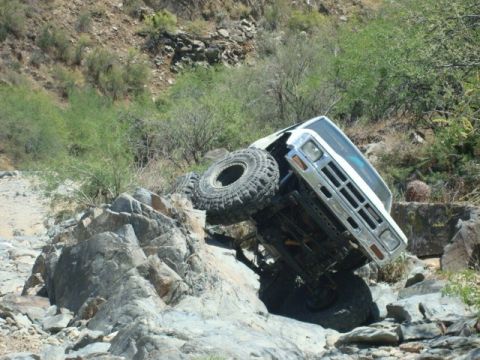 1986 Toyota Hilux - Pickup truck navigating a rocky off-road trail.