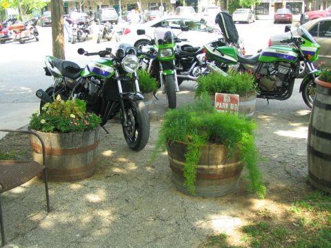 1981 Kawasaki Bayou - Several motorcycles are parked outside, with planters and a 'No Parking' sign visible.
