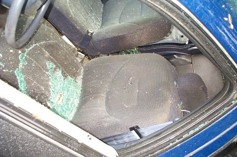 2001 Ford Crown Victoria - Interior of a car showing broken glass on the dashboard and seats.