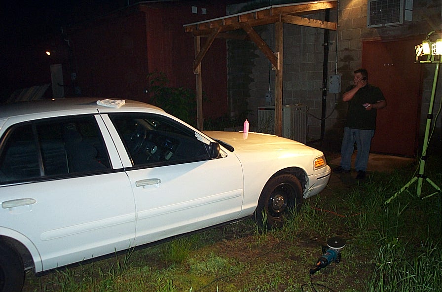 White 2001 Ford Crown Victoria sedan, front passenger side, parked on grass at night