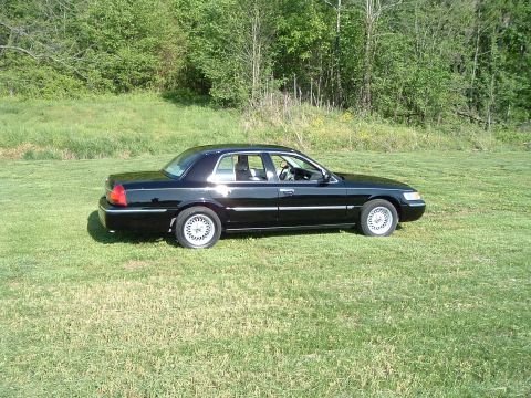 2001 Mercury Grand Marquis - Side view of a black 2001 Mercury Grand Marquis parked on a grassy area.