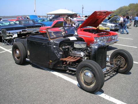 1995 Ford Bronco - A custom hot rod is displayed at an outdoor car show with other vehicles present.