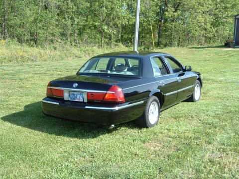 2001 Mercury Grand Marquis - Rear view of a black 2001 Mercury Grand Marquis parked on a grassy lawn.
