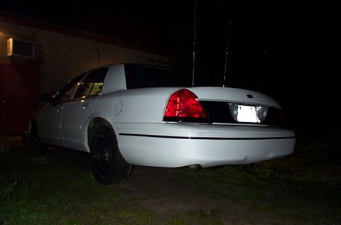 2001 Ford Crown Victoria - This white 2001 Ford Crown Victoria is parked outside a building at night.