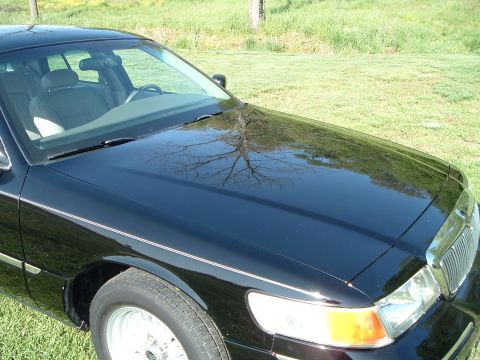 2001 Mercury Grand Marquis - Front corner of a black 2001 Mercury Grand Marquis, showing the hood, fender, and grille.