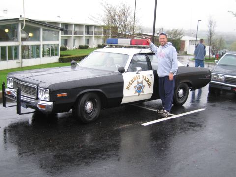 1991 Ford Crown Victoria - A man poses with a vintage highway patrol car on a wet day.