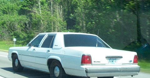2001 Ford Crown Victoria - Rear view of a white 2001 Ford Crown Victoria driving on a highway.