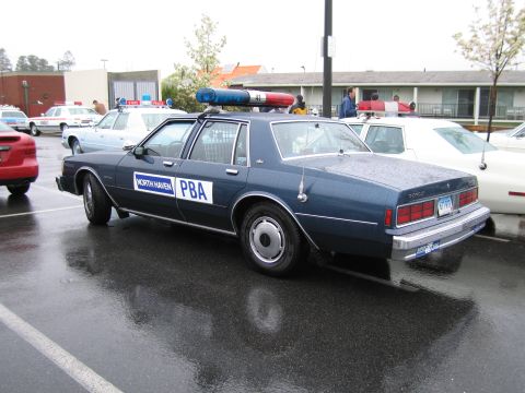 1991 Ford LTD Crown Victoria - dark blue police sedan lettered North Haven PBA with rooftop lightbar viewed from the rear in a wet parking lot.