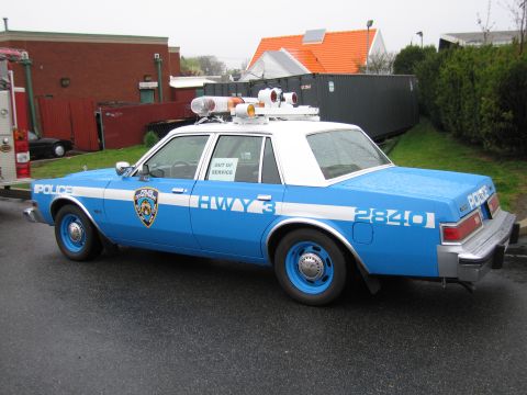 1991 Ford LTD Crown Victoria - blue-and-white NYPD Highway 3 Dodge police sedan numbered 2840 with rooftop lights, viewed from the rear.