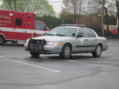 1991 Ford LTD Crown Victoria - silver Ford Crown Victoria State Police cruiser with a front push bar and roof lightbar parked near a red ambulance.