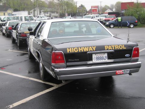 1991 Ford LTD Crown Victoria - black Ford Crown Victoria California Highway Patrol sedan from the rear three-quarter, lettered Highway Patrol with a California plate.